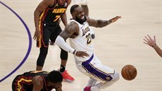 LeBron James (v bílém) z LA Lakers padá zranný po stetu se Solomonem Hillem z...
