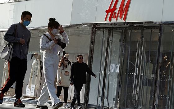 Lidé procházejí kolem zavřené prodejny švédského řetězce společnosti H&M v...