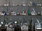 Pacienti s koronavirem leí v polní nemocnici zízené ve sportovní tlocvin...