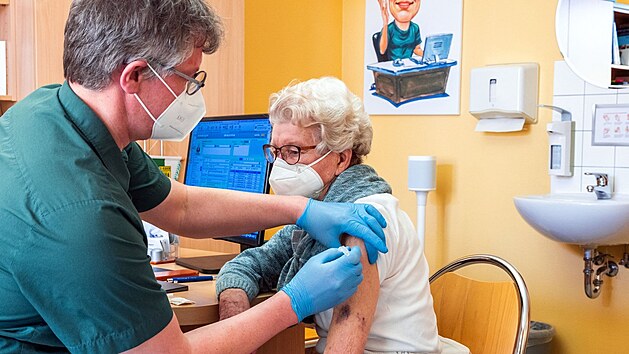 Praktický lékař Stefan Zutz podává pětadevadesátileté pacientce Ingeborg Ketelhohnové vakcínu proti koronaviru společnosti AstraZeneca. (26. března 2021)