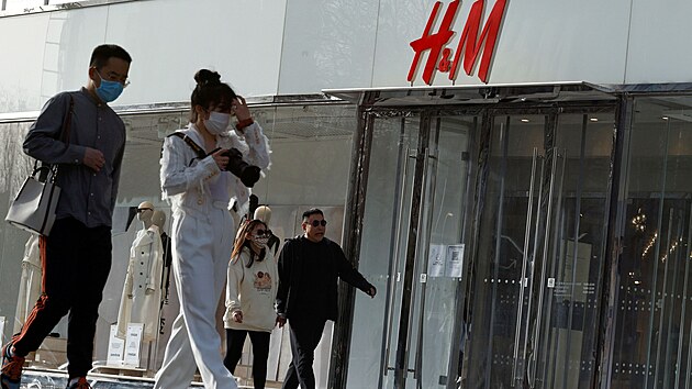 Lidé procházejí kolem zavřené prodejny švédského řetězce společnosti H&M v Pekingu. (28. března 2021)