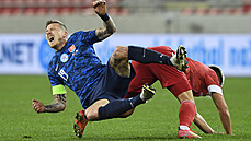 Juraj Kucka z reprezentace Slovenska padá po faulu jednoho z ruských hrá��.
