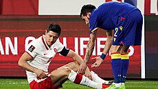 Polský kanonýr Robert Lewandowski se zranil, sklání se k n�mu Cristian Martinez...
