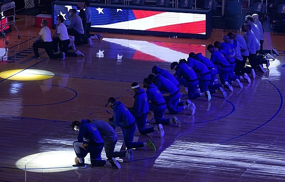 Hrái a trenéi Golden State Warriors kleí bhem poslechu hymny.