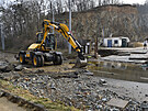 Bagr odstrauje 2. dubna 2021 následky havárie vodovodního potrubí v Brn. Voda...