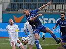 Olomoucký kapitán Roman Hubník (v modrém) hlavikuje bhem zápasu se Slováckem.