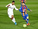 Lionel Messi (vpravo) vede balon v zápase proti Realu Madrid.
