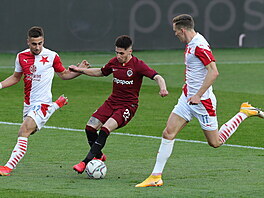 Srdjan Plav�i� (uprost�ed) ze Sparty se sna�í projít s balonem p�es fotbalisty...