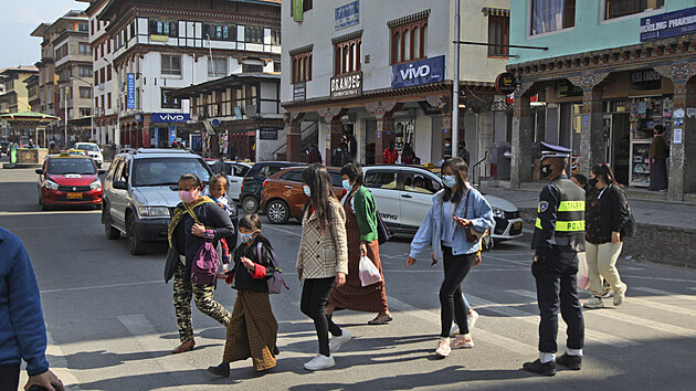 Lidé v rouškách se procházejí po ulici v bhútánském městě Thimbú. (1. dubna 2021)