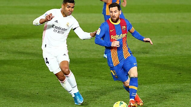 Lionel Messi (vpravo) vede balon v zpase proti Realu Madrid.