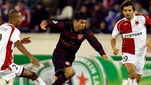Chorvatský útočník Eduardo z Arsenalu probíhá mezi slávistiy Mickaëlem...