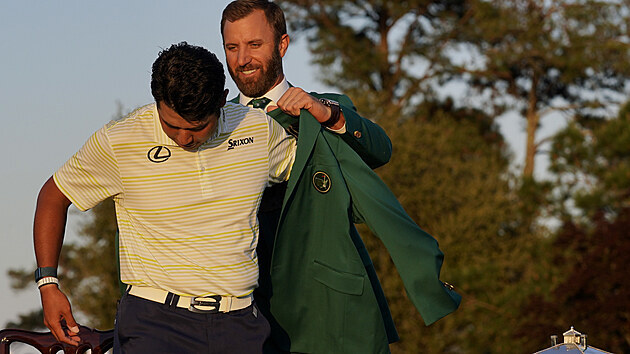 Hideki Macujama (vlevo) obléká zelené sako pro vítěze golfového Masters za asistence loňského šampiona Dustina Johnsona.