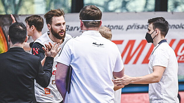 Fyzioterapeut Radek Petrů (vpravo) mezi trenérským štábem Nymburka povzbuzuje pivota Martina Kříže.