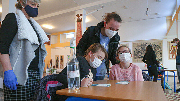 Děti s rodiči přicházejí první den obnovené školní docházky do 28. základní školy v Plzni - Lobzích. Před zahájením výuky čekalo každého žáka testování na koronavirus.(12. 4. 2021)