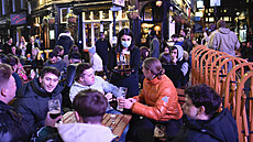 Lidé v londýnské čtvrti Soho slaví otevření zahrádek restaurací a hospod. (13....