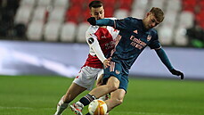 Slávista Jakub Hromada atakuje Emileho Smithe Rowea z Arsenalu v utkání...