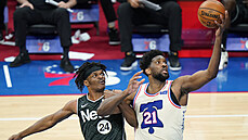 Joel Embiid (vpravo) z Philadelphie zpracovává mí a je bránný Alizem...