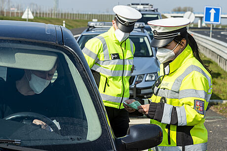 Policistka kontroluje 21. dubna 2021 doklady idii vozidla na sjezdu z dálnice...