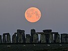 Pasoucí se ovce za svitu superúplku u Stonehenge poblí britského Amesbury,...