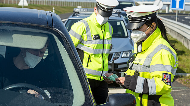 Policistka kontroluje 21. dubna 2021 doklady řidiči vozidla na sjezdu z dálnice D7 u Postoloprt na Lounsku, kde se měřila rychlost. Místo vybrala policie na základě hlasování občanů. Do celoevropské bezpečnostní akce nazvané Speed Marathon se policejní hlídky zapojily pošesté.