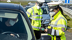 Policistka kontroluje 21. dubna 2021 doklady idii vozidla na sjezdu z dálnice...