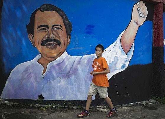 Chlapec prochází kolem obrazu nikaragujského prezidenta Daniela Ortegy ve mst...