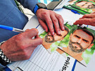 Robert lachta v rámci volební kampan podepisuje karty se svým portrétem. (28....