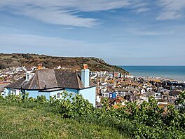 Z nemovitosti s modrou fasádou je nádherný výhled na přímořské město Hastings...