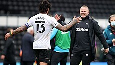 Trenér Wayne Rooney (vpravo) slaví s hráči Derby County na hřišti udržení se v...