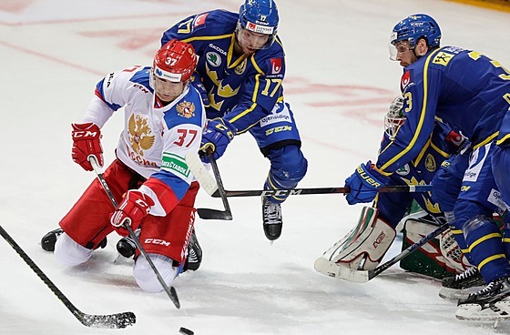 Ruský hokejista Jevgenij Timkin i(vlevo) bráněný Švédem Pärem Lindholmem.