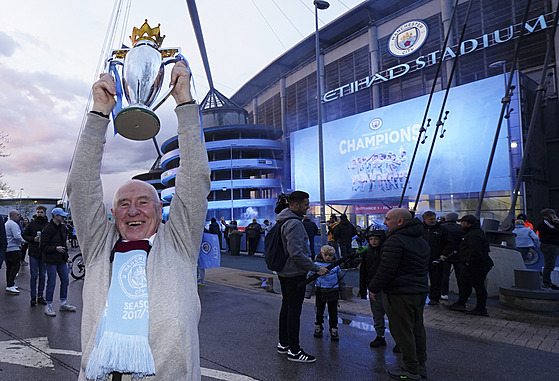 Fanouek Manchesteru City slaví ped Etihad Stadium s kopií trofeje pro...
