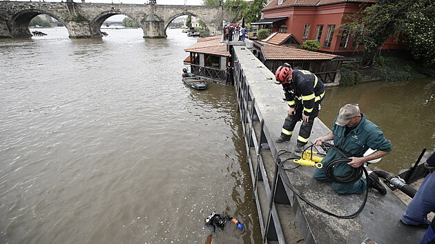 Potpi spolu s hasii kvli povodov vstraze uzavraj vrata na ce ertovce v Praze. (14. kvtna 2021)