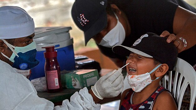 Zdravotnk v brazilskm Manausu provd chlapci test na koronavirus. (18. ledna 2021)
