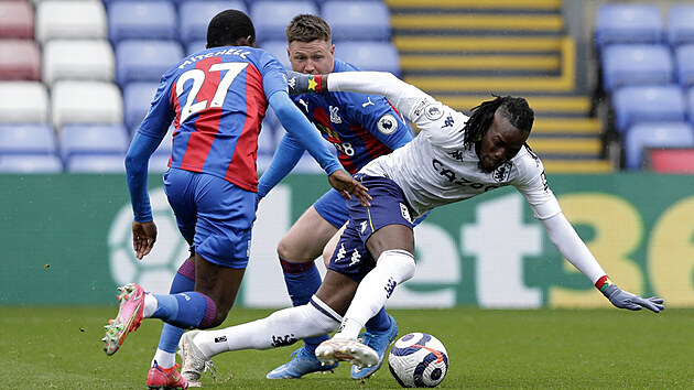 Bertrand Traoré z Aston Villy uniká s míčem dvěma hráčům Crystal Palace.