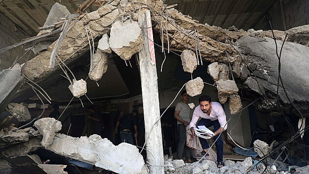 Palestinci v Gaze prohlej sutiny domu zasaenho bhem izraelskho bombardovn. (17. kvtna 2021)