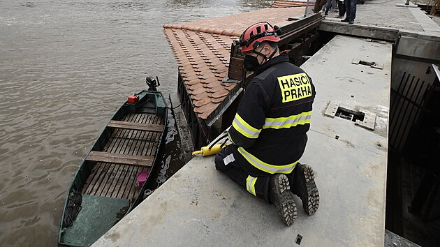 Potápěči spolu s hasiči kvůli povodňové výstraze uzavírají vrata na říčce Čertovce v Praze. (14. května 2021)