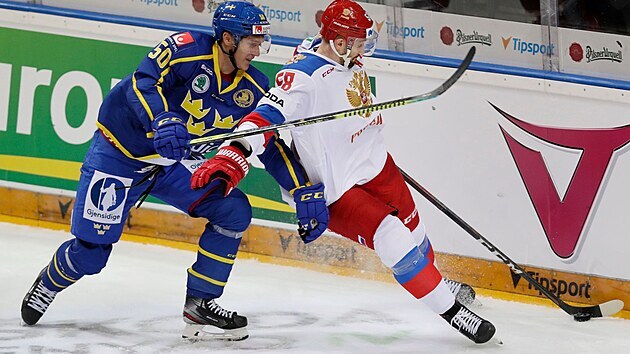 Ruský hokejista Anton Slepyšev (vpravo) se snaží vymanit z bránění Viktora Loova ze Švédska.