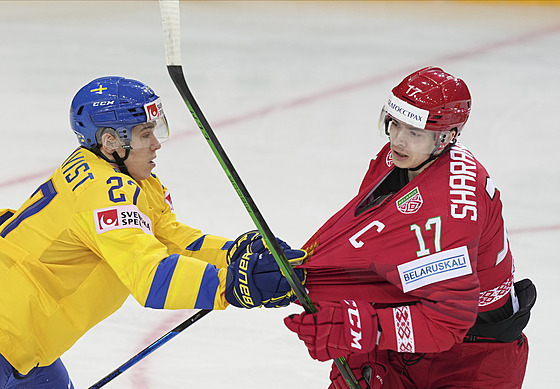 Švédský bek Nils Lundkvist (ve žlutém) chytá za dres běloruského útočníka...