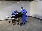 Zdravotníci v paraguayském San Lorenzu peváejí do márnice tlo pacienta,...