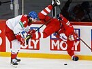 Ruský hokejista Konstantin Okulov padá krkolomn k ledu po stetu s echem...