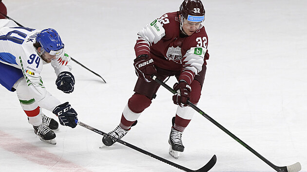 Italský hokejista Daniel Frank napadá Arturse Kuldu z Lotyšska.