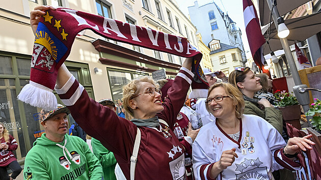 Fanoušci Lotyšska se radují z gólu před restaurací v centru Rigy 24. května 2021 při sledování utkání lotyšského týmu s Itálií na mistrovství světa v hokeji. Šampionát se  kvůli situaci se šířením nemoci covid-19 zatím hraje bez fanoušků na stadionech. Restaurační zahrádky jsou otevřené do 21 hodin.