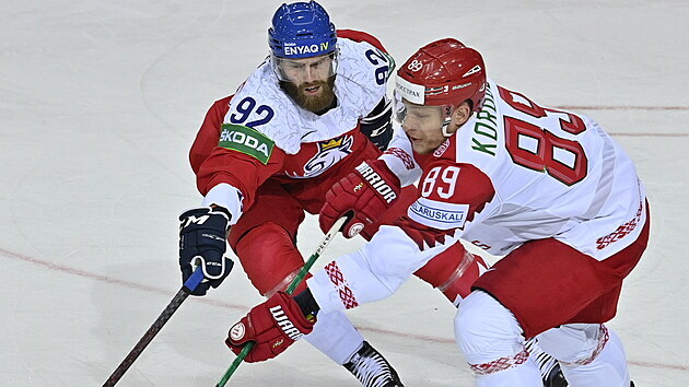 Jiří Sekáč a běloruský hokejista Dmitrij Korobov se přetahují o kotouč.