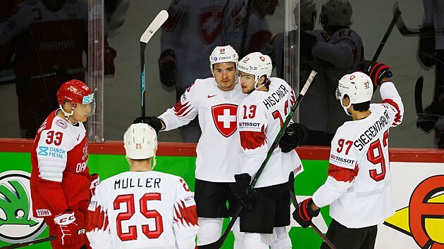 Švýcarští hokejisté (v bílém) oslavují gól Timo Meiera proti Dánům. V objetí se střelcem branky útočník Nico Hischier (13)