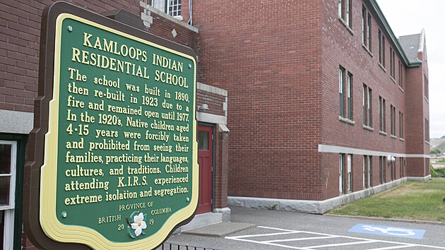 Cedule před bývalou internátní školou ve městě Kamloops upozorňuje na útisk, který v ní děti kanadských indiánů zažívaly. (27. května 2021)