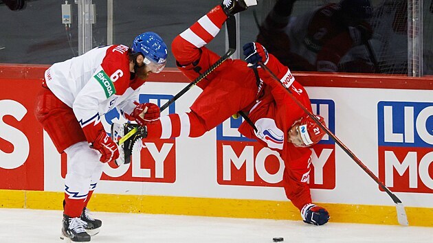 Ruský hokejista Konstantin Okulov padá krkolomně k ledu po střetu s Čechem Davidem Musilem.