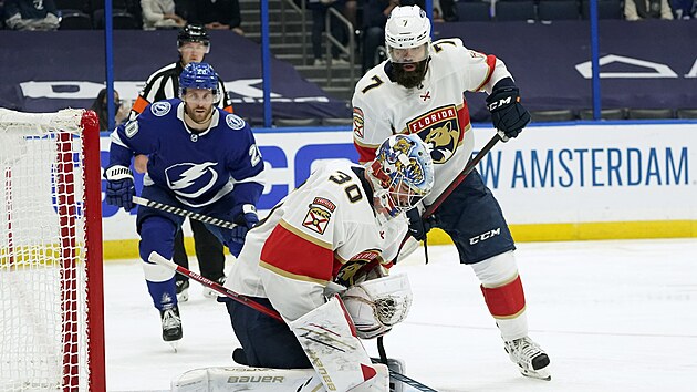 Radko Gudas (vpravo) z Floridy sleduje, jak si porad s pukem brank Spencer Knight . Vlevo Blake Coleman z Tampy Bay.