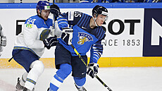 Finský útoník Anton Lundell (v modrém) s kotouem ped kazaským forvardem...