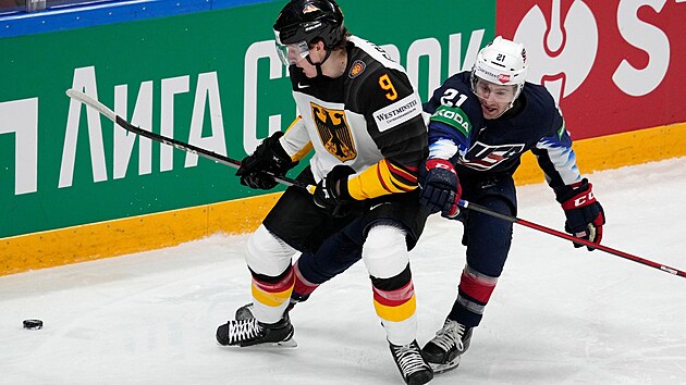 Americký hokejista Kevin Rooney (vpravo) napadá německého soupeře Leona Gawankeho.