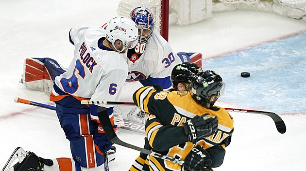 Brankář New York Islanders Ilja Sorokin a bek Ryan Pulock koušou zklamání, zatímco David Pastrňák a Patrice Bergeron oslavují gól Bostonu.
